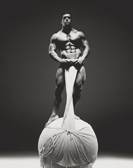 An original gelatin silver print by Jim French depicting the model Jake Tanner, a muscular white male with brown hair, posing nude in contrapposto on a white sphere.