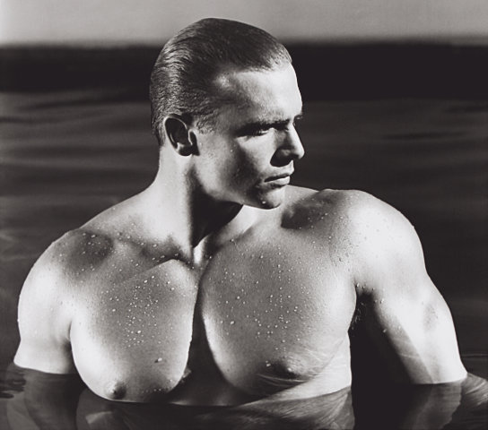 An original gelatin silver print by Jim French depicting the model John Pruitt, a muscular white male with blonde hair, posing nude in a swimming pool.