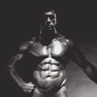 Jim French photograph "Jake Tanner, Studio" depicting the model Jake Tanner, a muscular white male with brown hair, posing nude in front of a black background.